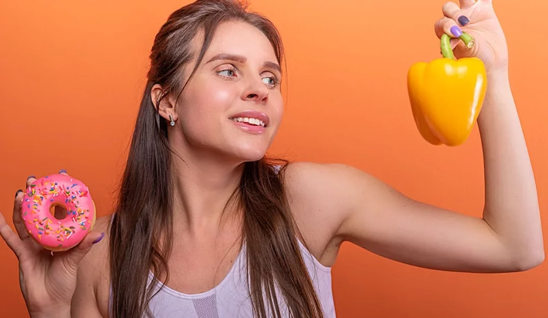 Aliments variés disposés sur une table, dont des fruits, du fromage et un verre d'eau, illustrant l'impact de l'alimentation